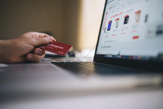 Bradford Telegraph and Argus: A person holding their bank card, shopping online. Credit: Canva