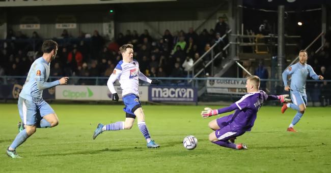 Adam Haw (second left) slides the ball agonisingly wide for Guiseley late on. Picture: Alex Daniel.
