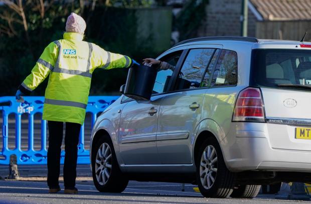 Bradford Telegraph and Argus: A member of NHS Test and Trace collects a sample from a member of the public at the drive-thru Covid-19 testing site (PA)
