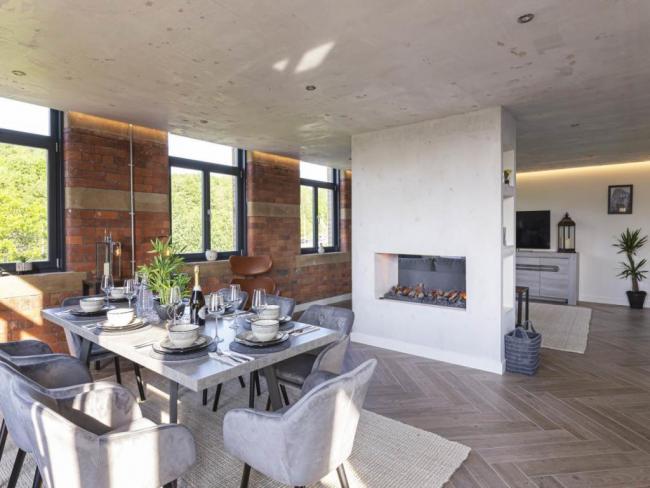 The dining area of the Conditioning House penthouse, Bradford's most expensive flat, with a standalone fireplace separating the dining and lounge space. All photos: Rightmove