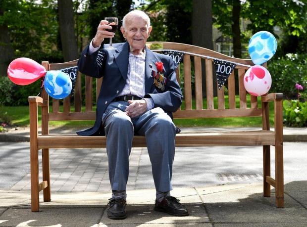 Bradford Telegraph and Argus: Frank sitting on a bench bought by fellow residents at Jowett Court 