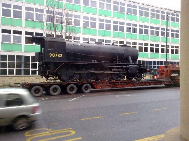 A picture of a steam train being transported past Keighley College, taken by Kallo Adalbert, of Devonshire Street, Keighley.