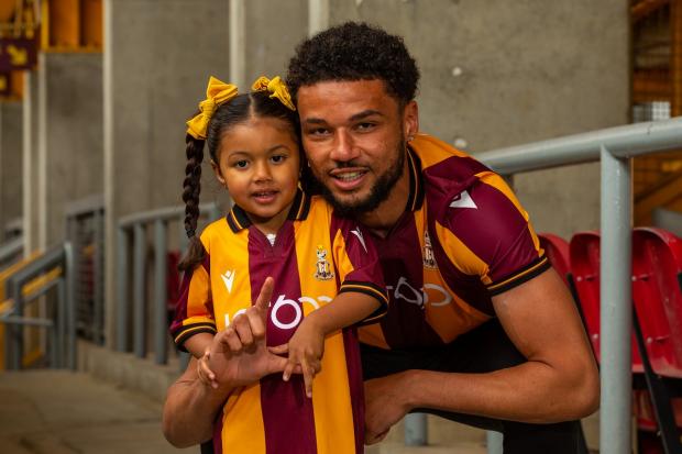 Bradford Telegraph and Argus: Lee Angol wearing the new home shirt, alongside his daughter. Picture: Thomas Gadd.