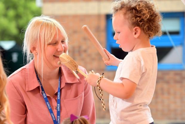 Bradford Telegraph and Argus: Deputy childcare and education manager Kate Hough helps a children with a musical instrument.