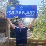 Ryan Hoyle, 38, with his National Lottery win of £58,366,487 (Camelot/PA)