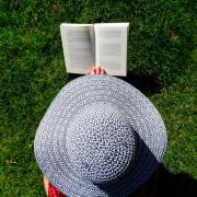 A woman in a hat reading. Credit: Canva