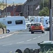 Travellers’ vehicles queuing on Old Bank Road in Mirfield as they wait to enter a recreation ground
