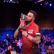 Joe Cullen celebrates with the Masters trophy after beating Dave Chisnall in the 2022 final.