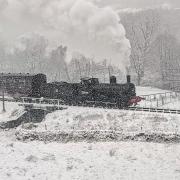 A train part of the Keighley and Worth Valley Railway Steam Gala travels through the snowy countryside