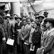 PA photo dated 22/06/48 of Jamaican immigrants welcomed by RAF officials from the Colonial Office after the ex-troopship HMT 'Empire Windrush' landed them at Tilbury