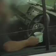Watch the moment police catch driver sipping mug of tea with hands off the wheel