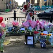 Floral tributes to both victims have been left on a bench outside The Victoria Theatre