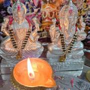 Diya in front of silver Ghanesh statues