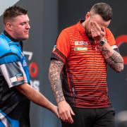 Joe Cullen (right) gets a sympathetic hand from Daryl Gurney on Saturday at the Masters.