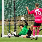Isaac Khan plunges to his right to make what turned out to be a decisive penalty save yesterday.
