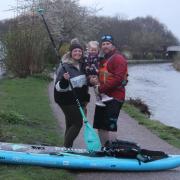 Jonathan Callow with his partner Anna Hall and daughter Eira at the finish of 300km paddle board challenge.