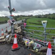 Floral tributes at the site of a fatal crash
