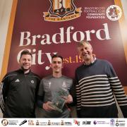 Jamie Walker (centre) is presented with the PFA Community Champion award by Foundation CEO Ian Ormondroyd (right) and PFA Community Liaison Executive Ben Parker (left). Photo: Bradford City