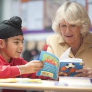 Literacy charity Beanstalk’s patron the Duchess of Cornwall offers some reading help to a young pupil