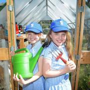 Sisters, Ruby and Lilly Lovett getting to work in the greenhouse in St Columba's School's Quad Garden.