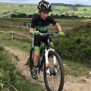 Keelham Primary School pupil Ryden Hindle on his way to gold and silver in the regional and national mountain bike event at wild and windy Penistone Hill Country Park in Haworth
