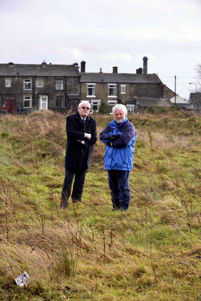 SITE: David Ryan (left) and Councillor Paul Cromie on the site of the new pitch that is still strewn with rubble