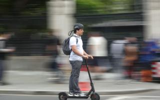 A man riding an electric scooter. Credit: PA