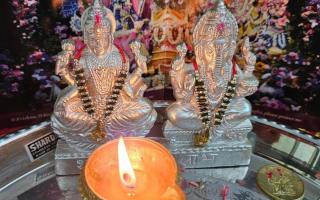 Diya in front of silver Ghanesh statues
