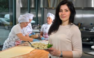 Oksana Kateryniak holds a plate of freshly made goods in the Multi Cook kitchen