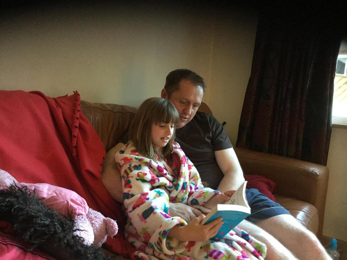 Dave Dickens reading to his daughter Jasmine, aged 8. Their favourite book is Gangsta Granny by David Walliams.