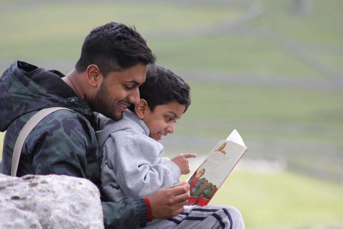Aun Muhammed reading to his son Muhammed Ali Asghar, aged 3. Their favourite book is Traction Man by Mini Grey.