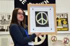 Holding an example of the CND logo is Peace museum trustee Lauren Padgett.